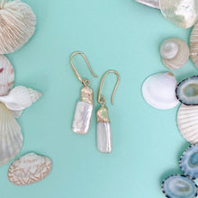 Load image into Gallery viewer, the beach and back freshwater pearl rectangular drop earring on aqua background with shells