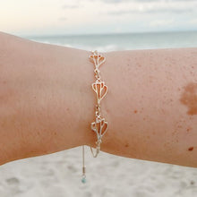 Load image into Gallery viewer, the beach and back plum island triple slider bracelet on wrist with beach and ocean in the background
