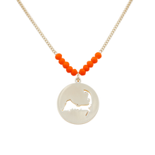Load image into Gallery viewer, the beach and back cape cod necklace in gold with coral beads at center of chain and coin shape pendant with cutout silhouette of cape cod
