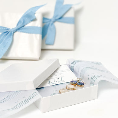 the beach and back gift wrap with signature wave and sea gull pattern  tissue paper with white paper wrap and turquoise ribbon bow
