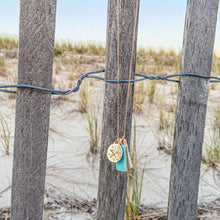 Load image into Gallery viewer, mantoloking charm necklace with semi-precious turquoise pendant freshwater stick pearl and seastar charm hanging on beach fencing
