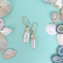 Load image into Gallery viewer, the beach and back freshwater pearl rectangular drop earring on aqua background with shells

