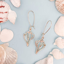 Load image into Gallery viewer, the beach and back plum island whelk shell shape drop earrings on light blue background with white shells
